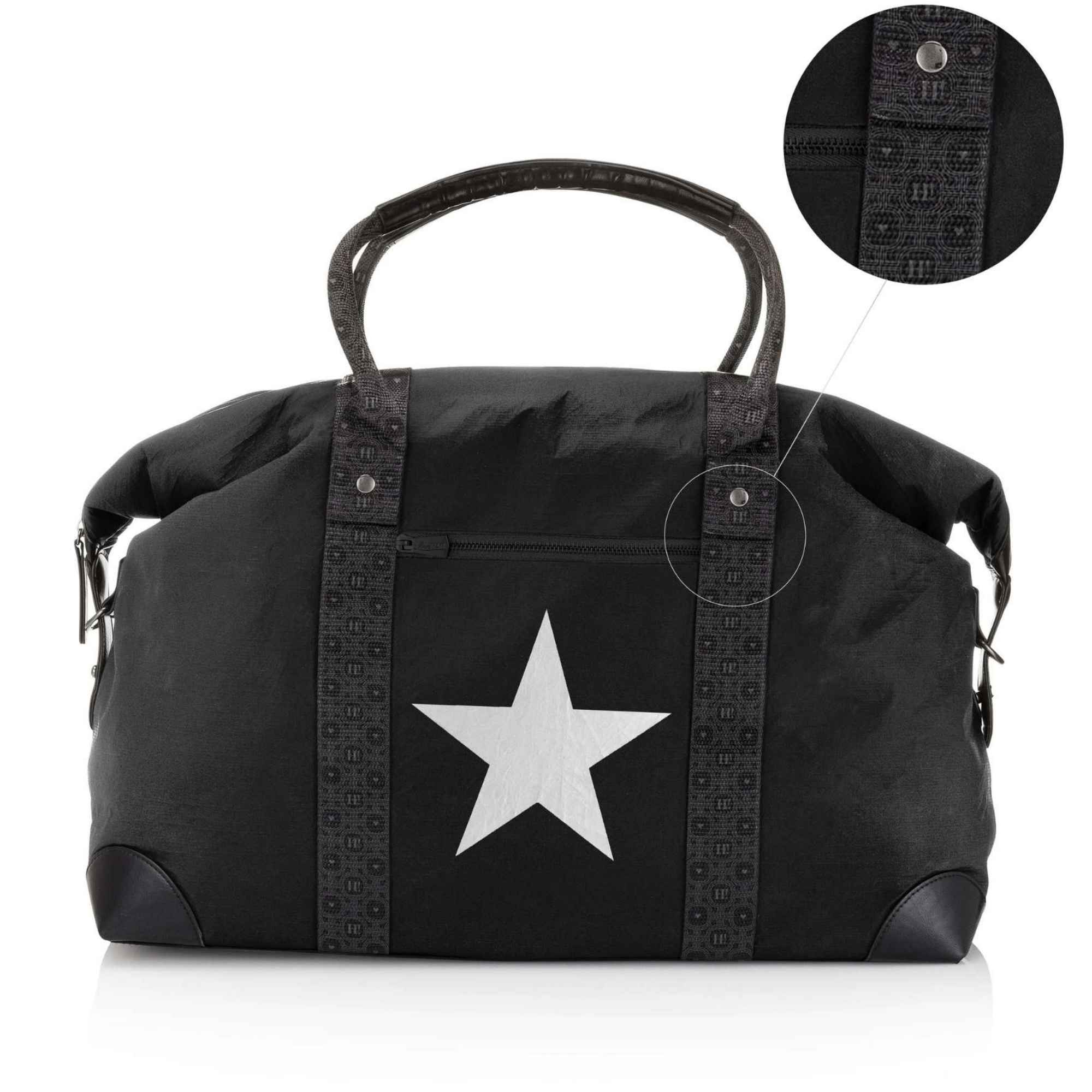 Black duffel bag with a large silver star on the front, signature patterned straps, and a circular inset detail showing a close-up of the strap texture.