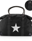 Black duffel bag with a large silver star on the front, signature patterned straps, and a circular inset detail showing a close-up of the strap texture.
