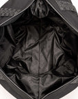Close-up view of the spacious interior of a black weekender bag, featuring a sleek tonal patterned lining, wide zippered opening, structured sides, and multiple interior details. The soft fabric lining showcases a subtle repeating geometric and monogram-inspired pattern throughout the main compartment and side panels.