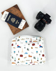 White Medium Zipper Pouch with World Landmarks Pattern next to passport and camera