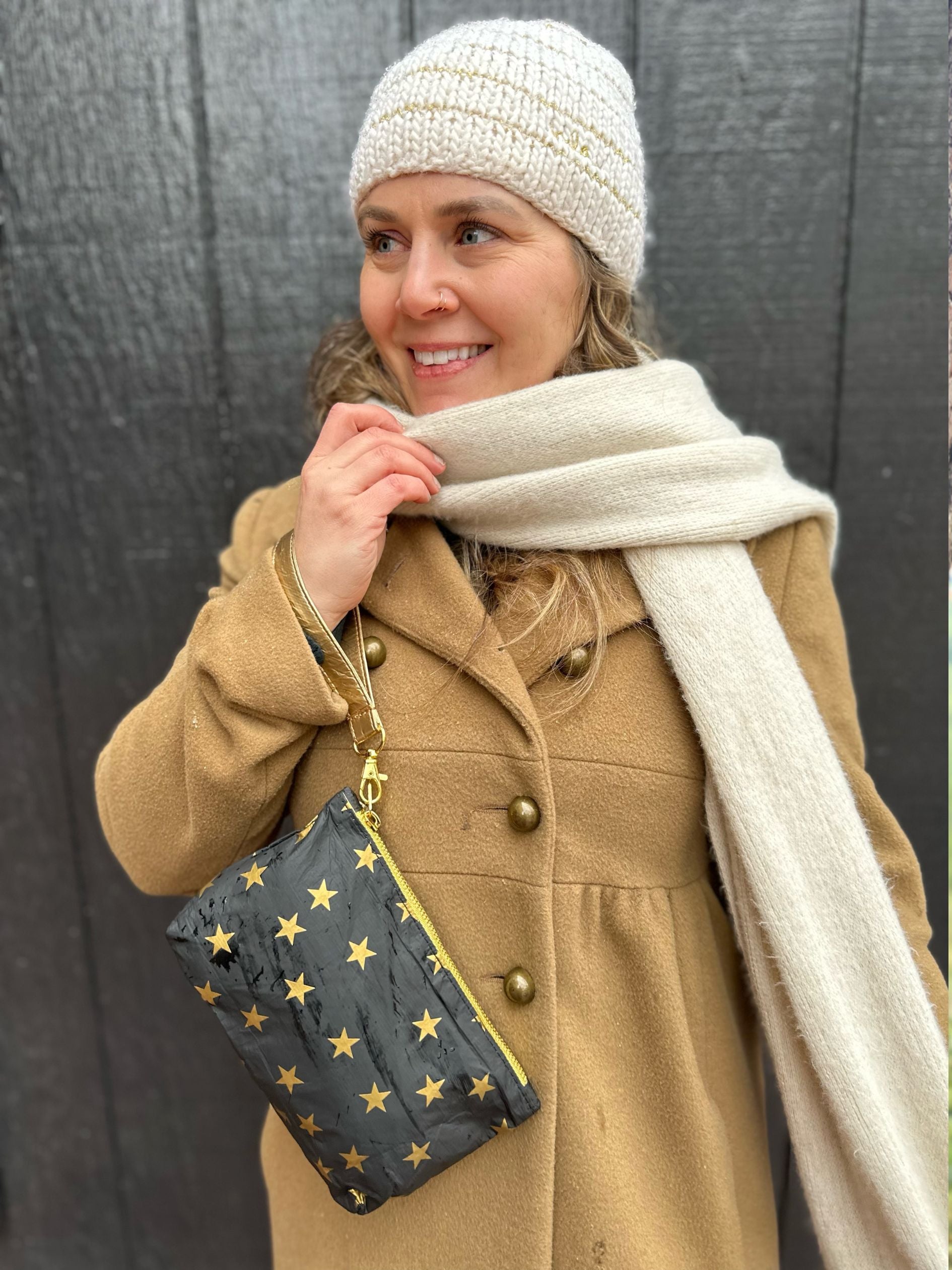 Woman carrying Zip wristlet in black with detachable strap