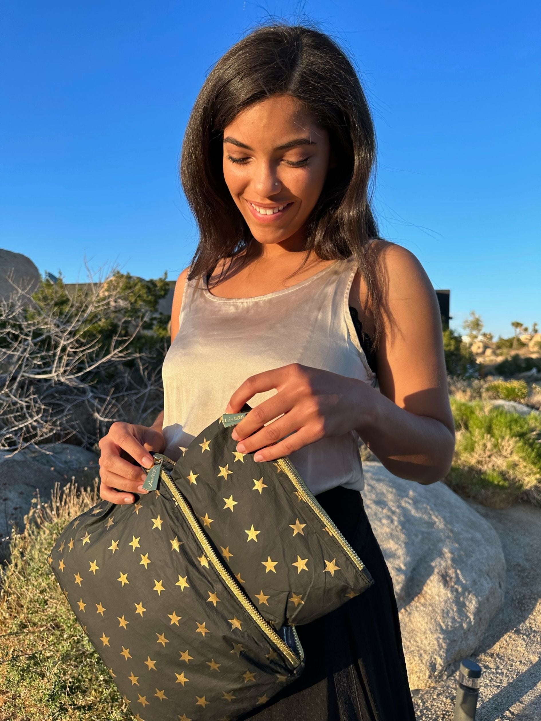 Woman using the Medium and mini pouches in black with gold stars