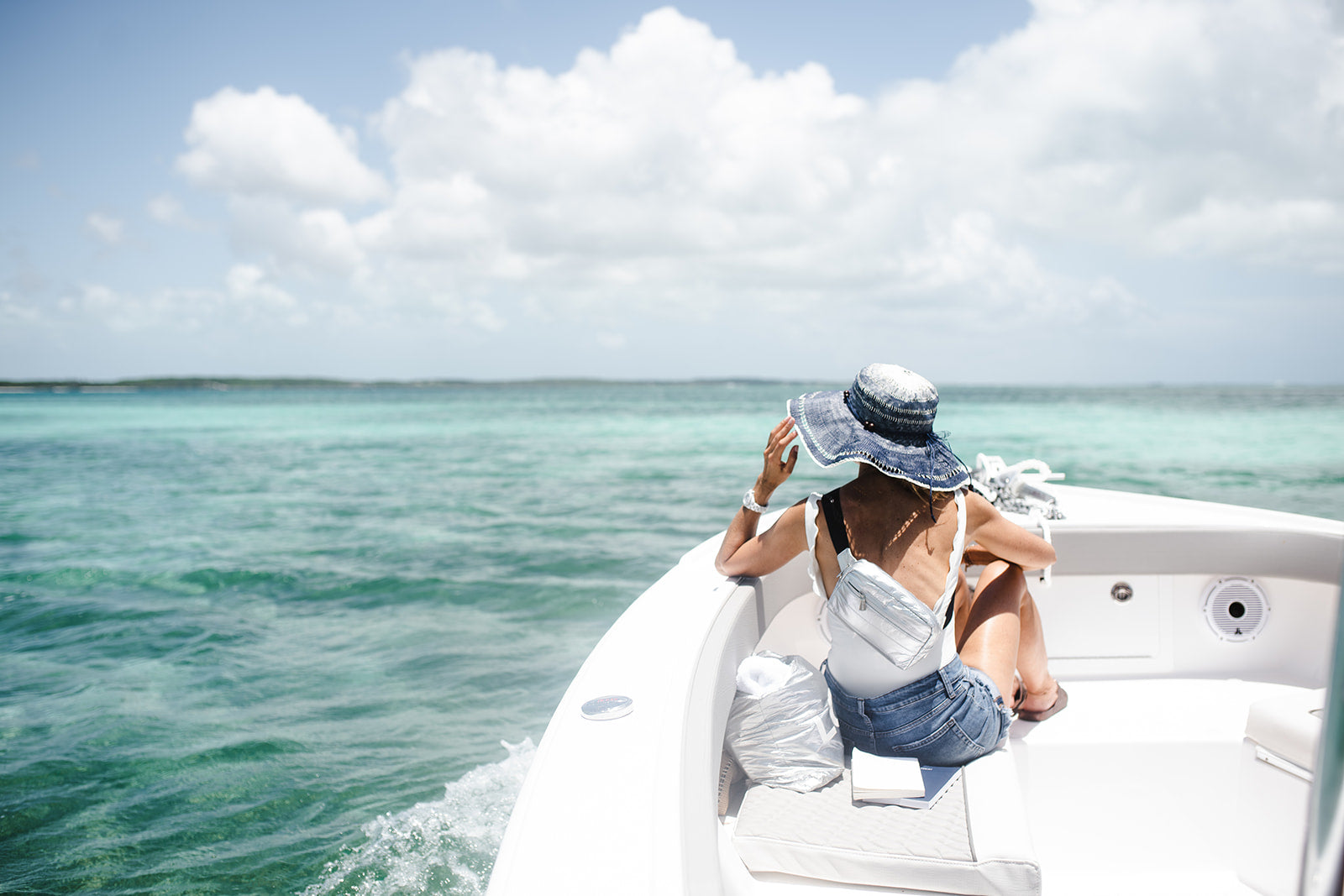 Woman on boat wearing Puffer Crossbody Fanny Pack Belt Bag in Silver with Black Strap