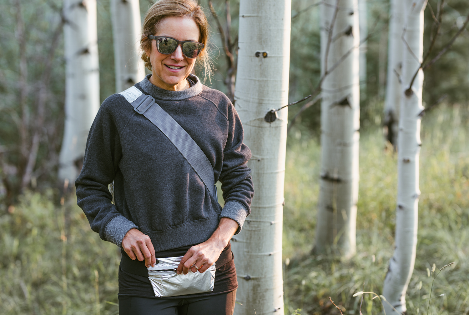 Woman in forest wearing silver fanny pack
