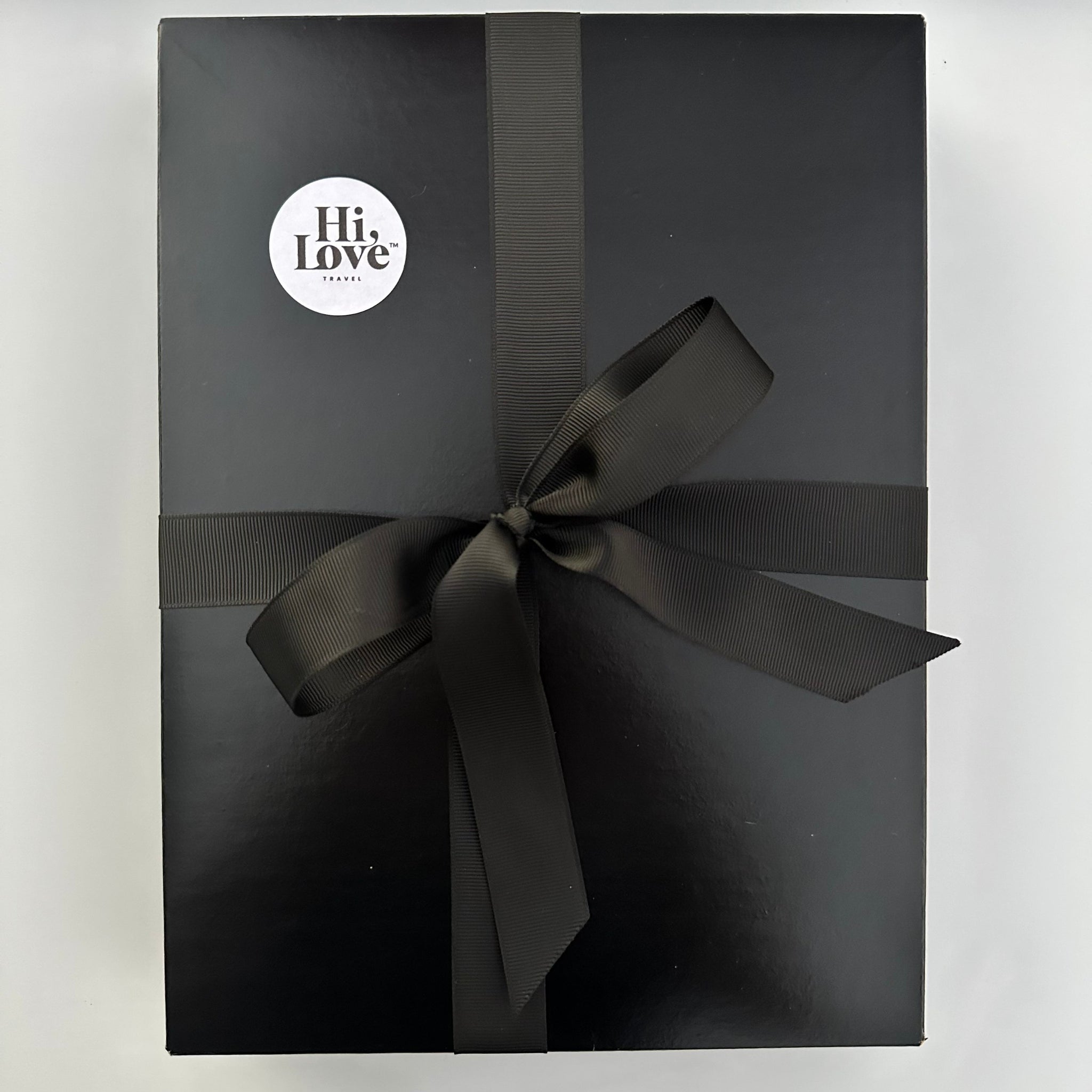 Black gift box with black bow and white Hi Love sticker on top