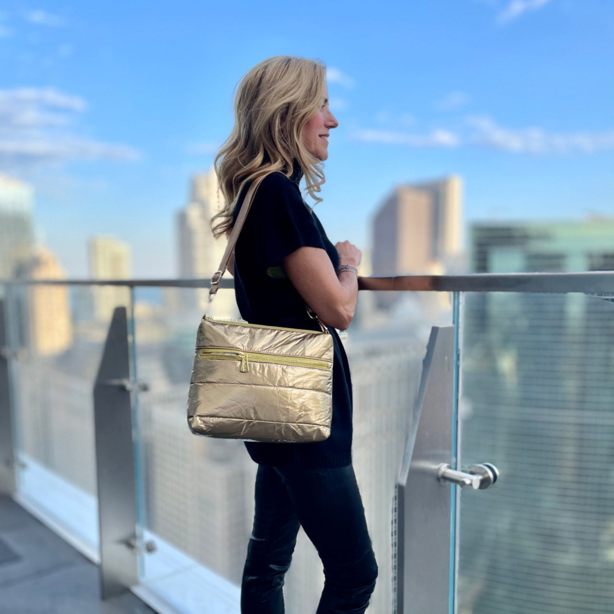 Woman in city wearing a gold puffer purse as shoulder bag