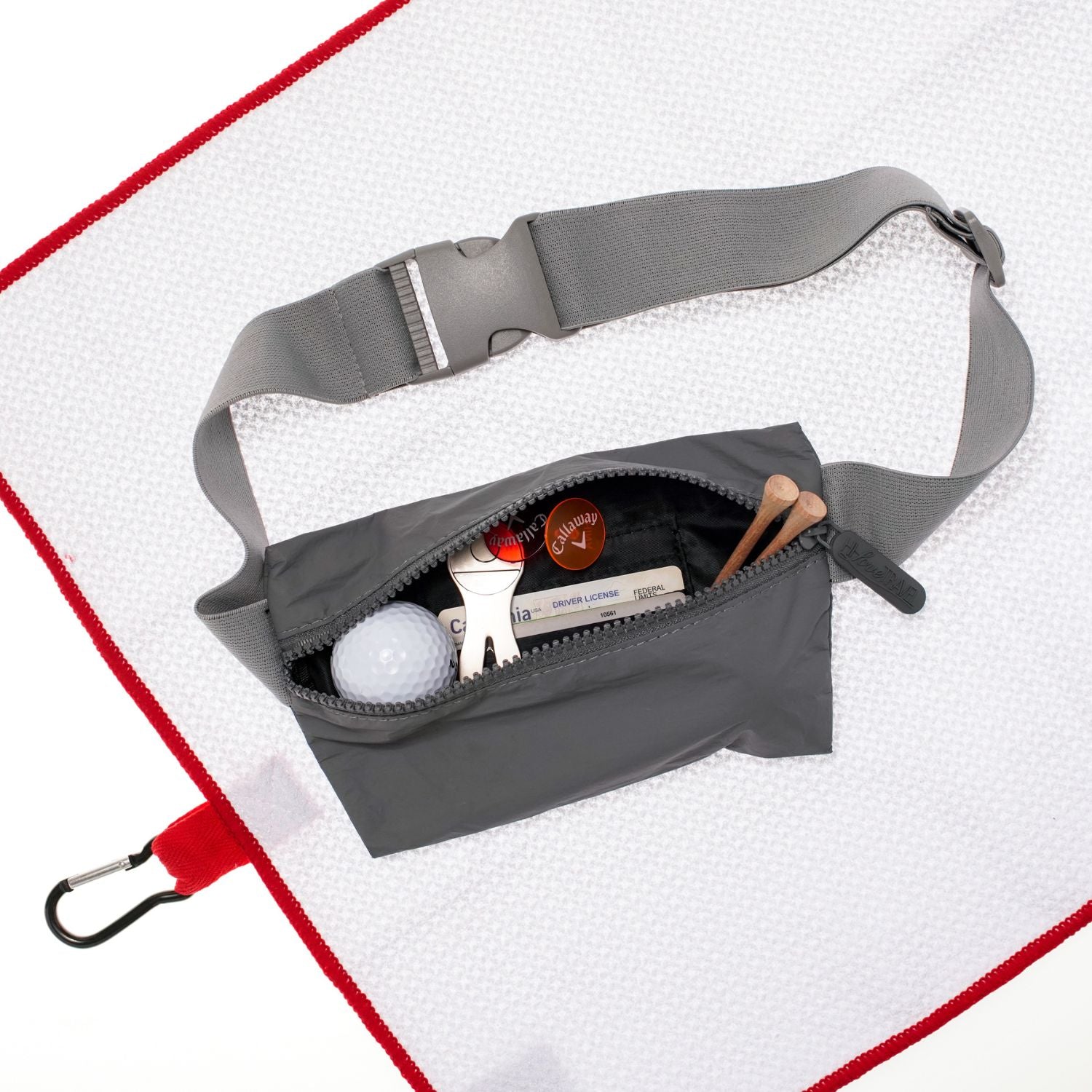 Layflat Fanny Pack Belt Bag in Cool Gray with golf supplies on white background