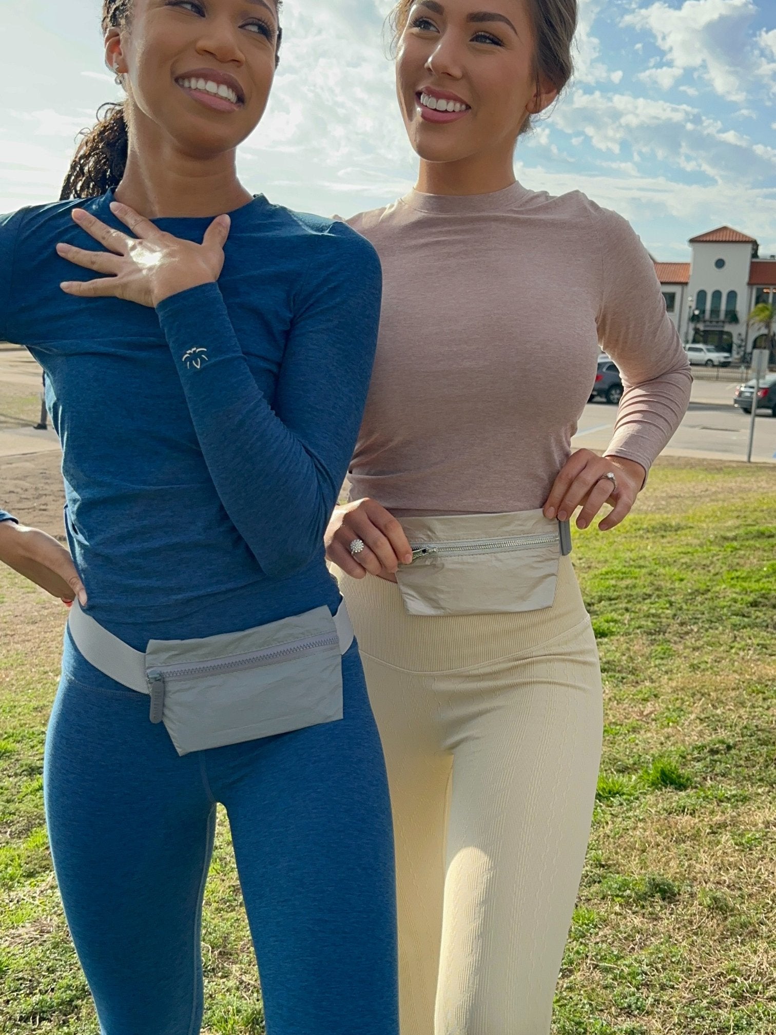 Women posing wearing lay flat fanny pack belt bag in shimmer gray