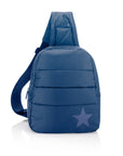 Puffer crossbody backpack in shimmer navy with tonal star on white