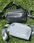 Puffer Crossbody Fanny Pack Belt Bag in Shimmer Gray and Shimmer Black on gross Background