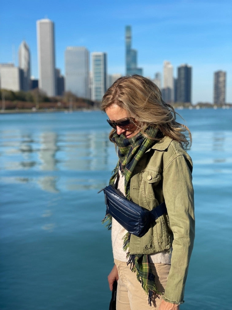 Woman overlooking Chicago skyline wearing Puffer Crossbody Fanny Pack Belt Bag in Shimmer Navy Blue