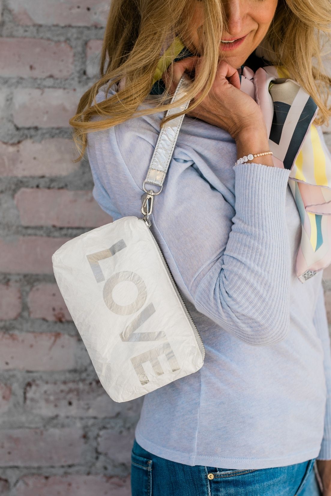 Lightweight stylish zip wristlet in shimmer white with silver "LOVE"