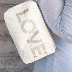 Lightweight and versatile mini padded zipper pack in shimmer white with silver "LOVE"