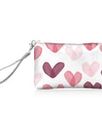 White zip wristlet with multicolored pink hearts and silver wrist strap on white background