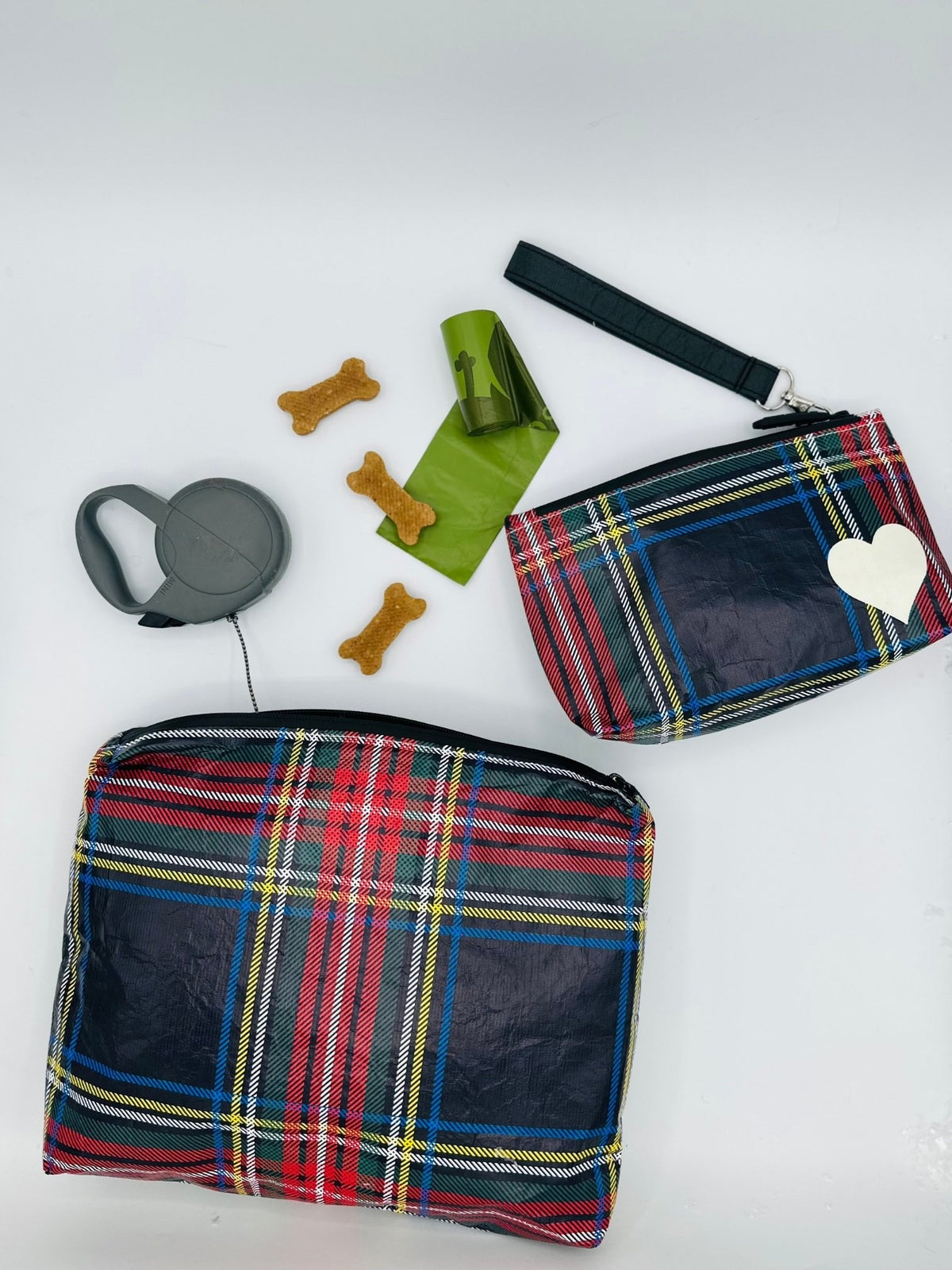 Medium and mini zipper pouch in tartan plaid pattern with dog bags and treats surrounding on white background