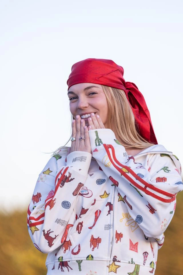 Woman wearing the Howdy & Happy zip-up, face and zipper visible